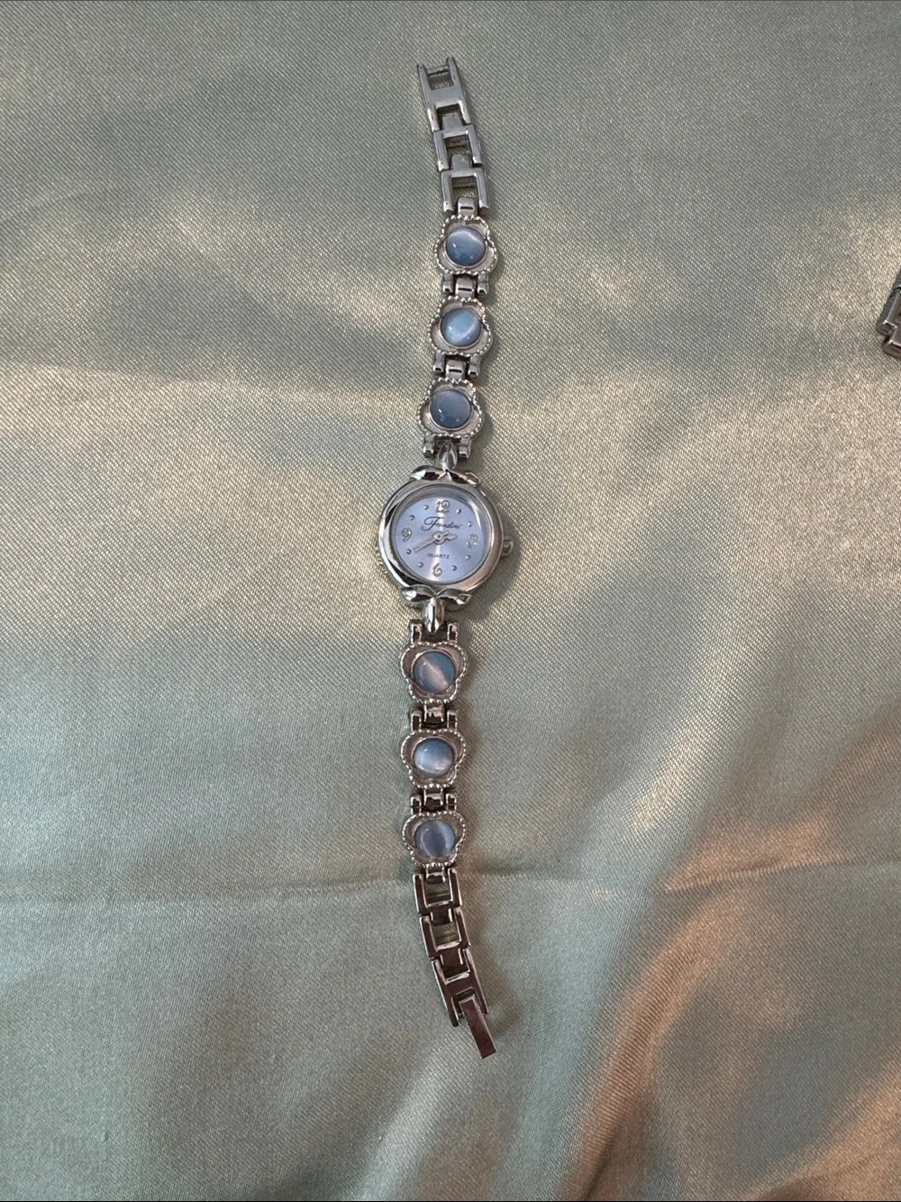 Fondini Silver Tone Women's Bracelet Watch with Light Blue Accents.